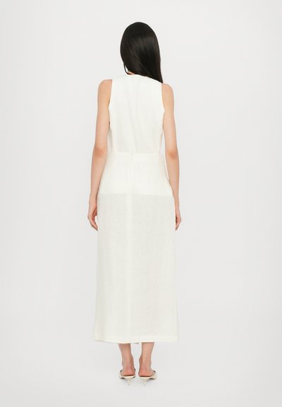 Long, sleeveless white dress made of lightweight linen, featuring a simple design, slightly flared hem, and a center back zipper.