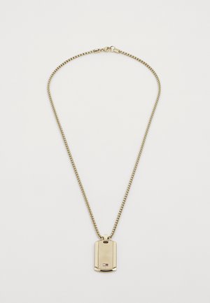 Collier en chaîne dorée avec un pendentif rectangulaire. Le pendentif présente un motif en éclat de soleil texturé et un petit logo en bas.