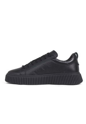 Sneaker nero low-top con tomaia in pelle testurizzata, suola piattaforma spessa con coste, chiusura con lacci e collo imbottito.