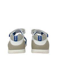 Sandali bianchi e beige con accenti blu, dotati di una cintura in velcro, un tallone imbottito e una superficie testurizzata per il comfort.