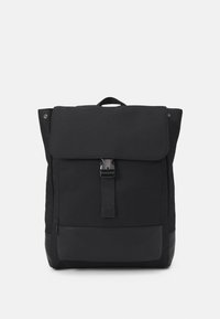 Sac à dos noir avec une fermeture à rabat, doté d'une boucle et d'une poche zippée. Fabriqué en tissu durable avec une texture lisse et une base robuste.