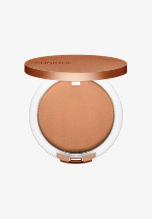 Kompakter Bronzer mit einer glatten, matten Bronze-Oberfläche, untergebracht in einem klaren Kunststoffgehäuse mit einem kreisförmigen Deckel in Roségold.