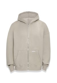 Hettegensere med glidelås i lys beige farge, laget av mykt stoff, med en frontglidelås, kengurulommer og ribbede mansjetter.