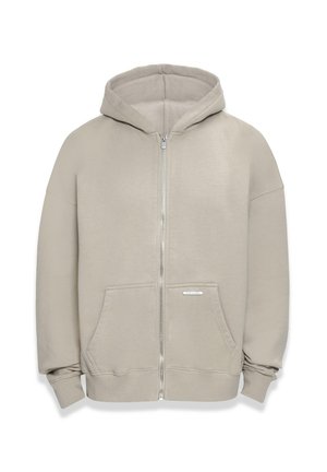 Hooded zip-up sweatshirt in a light beige color, made of soft fabric, featuring a front zipper, kangaroo pockets, and ribbed cuffs.