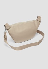 Beige synthetisch leren tas met een gestructureerde vorm, verstelbare stoffen schouderband en metalen details. Voorzien van gestikte accenten aan de uiteinden van de band.