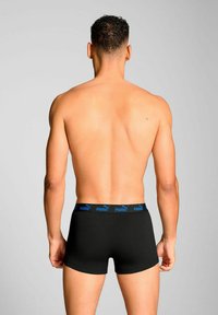 Black boxer briefs with a blue waistband featuring a logo. The fabric appears smooth and fitted, with a simple design and mid-rise cut.