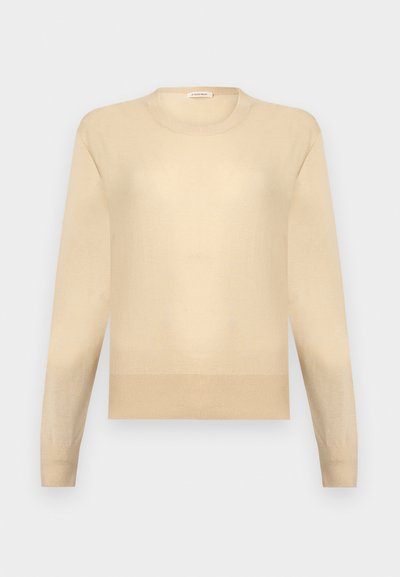 Pull beige à manches longues et col rond avec poignets et ourlet côtelés sur un fond gris clair.