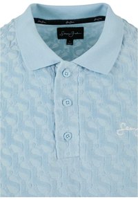 Polo bleu clair avec un motif texturé, trois boutons, un col classique et un logo brodé sur le devant.