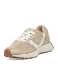 Zapatillas con una parte superior de ante y malla en color beige, detalles en blanco, cordones redondos y una suela de goma marrón claro con un dibujo texturizado.