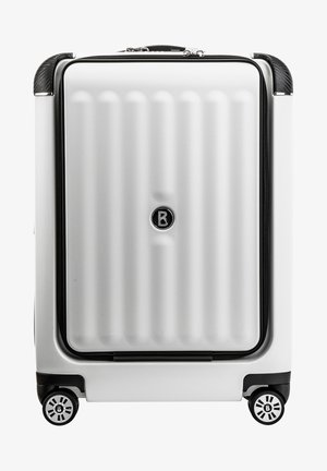 Kovakirstu hopeanvärinen, pystysuorilla urilla, mustalla vetoketjulla ja pyörillä, joissa on pyöreä muotoilu logolla.