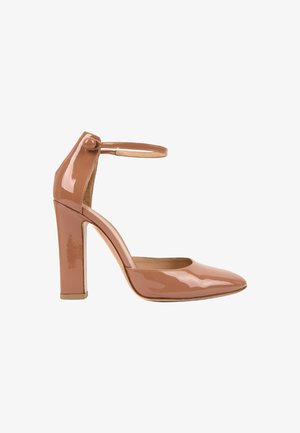 Escarpin à talon haut en cuir verni couleur nude avec bout pointu et bride à la cheville fermée par un bouton rond.
