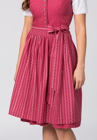 Dirndl-Kleid mit rotem und weißem Muster, das einen taillierten Oberteil, eine Knopfleiste, einen gerafften Rock und eine gebundene Taillenbetonung aufweist.