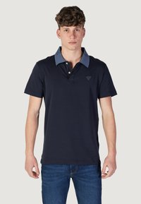Polo navy in cotone con colletto azzurro chiaro, caratterizzato da un logo triangolare sul petto e maniche corte. Design a taglio dritto.