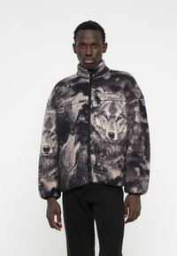 Φούτερ ζακέτα με εκτύπωση λιονταριού σε αποχρώσεις του γκρίζου. Περιλαμβάνει ψηλό γιακά και μπροστινό φερμουάρ, με χαλαρή εφαρμογή.