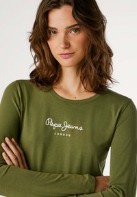 Armeegrünes Langarmshirt mit Rundhalsausschnitt, verziert mit dem weißen "Pepe Jeans London"-Logo in Schreibschrift über der Brust. Weicher Stoff.
