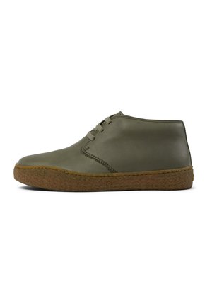 Botas de tobillo de cuero verde oliva con punta redonda, detalles de costura lateral y una suela de goma marrón texturizada. Diseño con cordones.