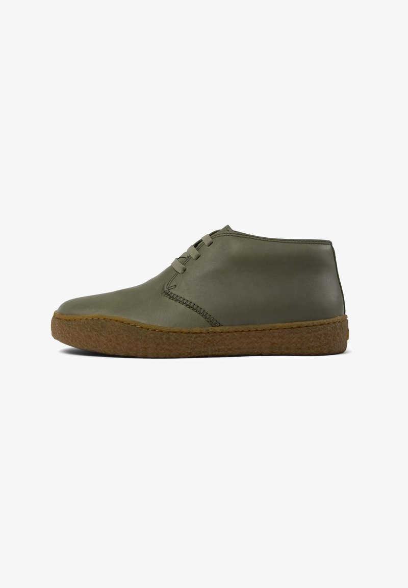 Olive green leather ankle boots featuring a rounded toe, side stitching detail, and a textured brown rubber sole. Lace-up design.
