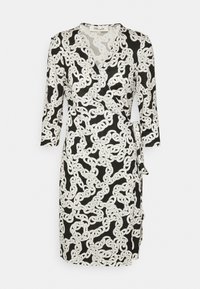 Knytdress i svart med vitt kedjemönster. Designad med långa ärmar och detalj med knyt i midjan. Tillverkad av lättviktsmaterial.