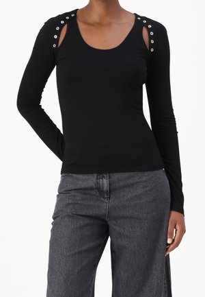 Sort langærmet top i en tætsiddende pasform med udskæringer ved skuldrene og detaljer med sølvfarvede nitter. Blødt, strækbart stof med en glat tekstur.