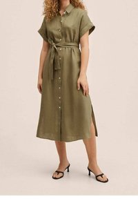 Olivengrøn skjortekjole med korte ærmer, bælte i taljen, sideslids og glat stof; kombineret med sorte sandaler med stropper.