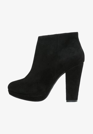 Černé nubukové kotníkové boty s vysokým blokovým podpatkem a kulatou špičkou, které mají hladkou texturu a minimalistický design.