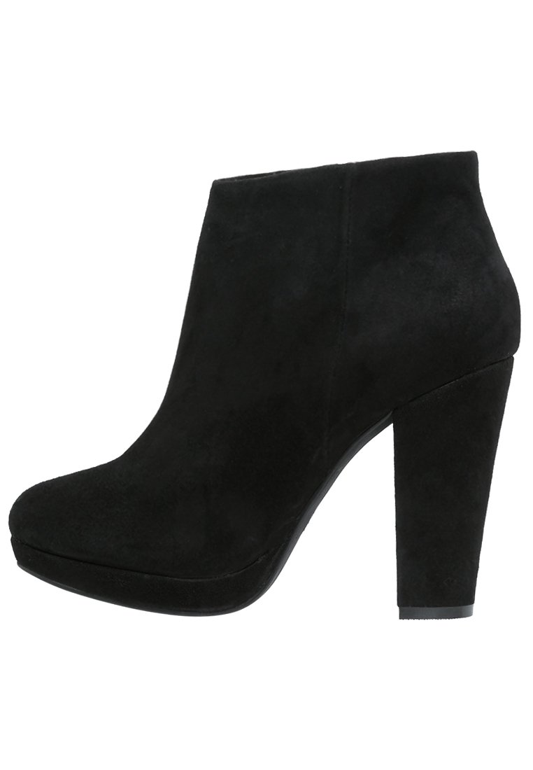 Botines de ante negros con tacón cuadrado alto y punta redondeada, que presentan una textura suave y un diseño minimalista.