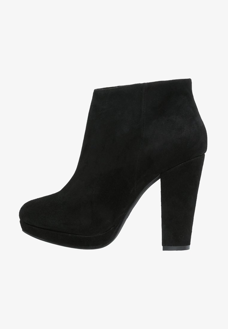 Botines de ante negros con tacón cuadrado alto y punta redondeada, que presentan una textura suave y un diseño minimalista.