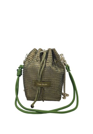 Petit sac vert à cordon avec motif quadrillé, étiquette « Craie Studio » et longues bandoulières vertes et chaîne.