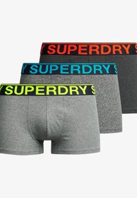 Trzy pary męskich bokserków; szara tkanina z czarnymi, niebieskimi i pomarańczowymi gumkami w talii, na których znajduje się logo "SUPERDRY" w kontrastowych kolorach.