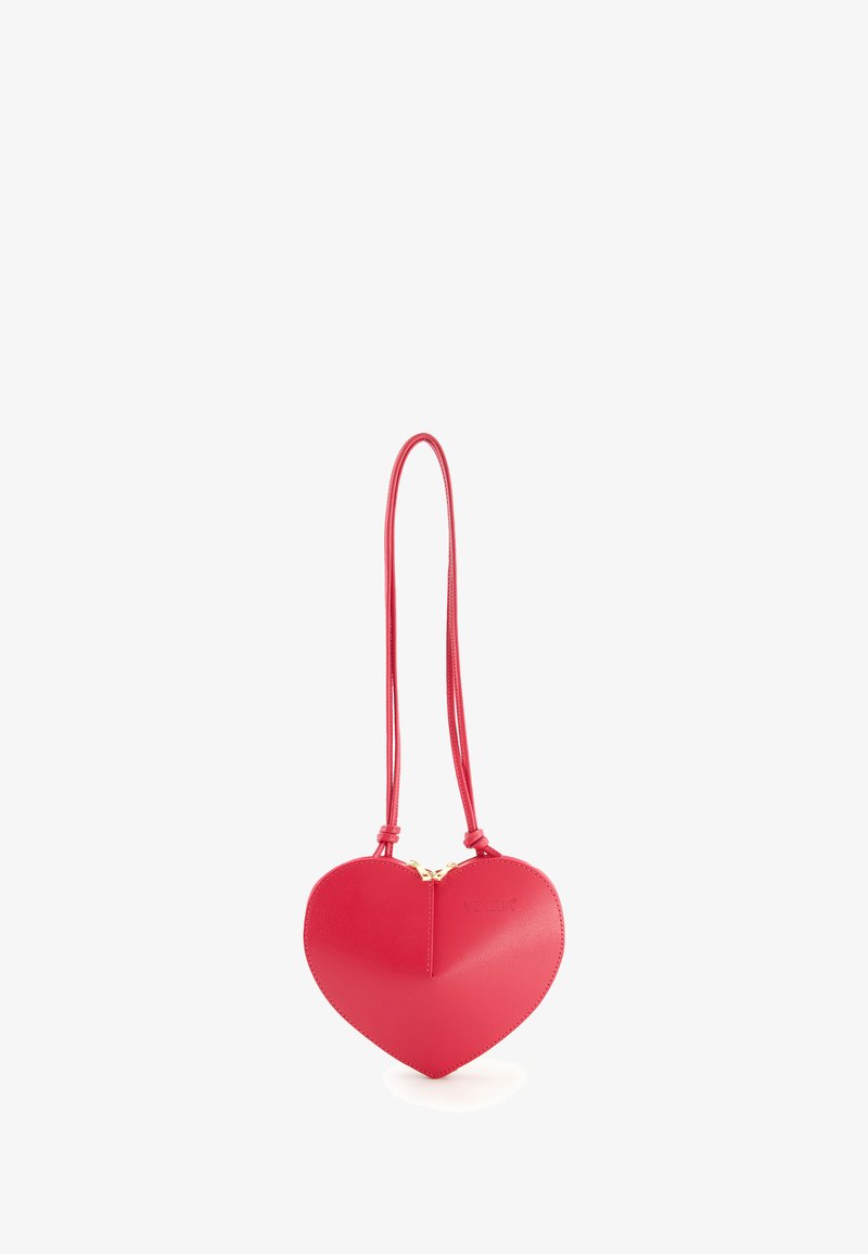 Rote herzförmige Lederhandtasche mit glatter Oberfläche, goldener Reißverschluss und langem passendem Gurt für das Tragen über die Schulter.