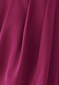 Magenta látka s hladkou, mierne lesklou textúrou; splýva s jemnými záhybmi, zdôrazňujúc bohatú farbu a rovnomerné splývanie.