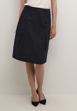 Jupe bleu marine, longue jusqu'aux genoux, en coton, comportant deux poches cargo latérales, avec une texture lisse et un design droit.