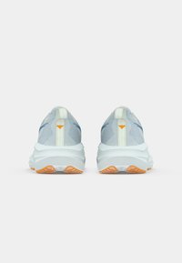 Light blue sneakers with a textured upper, pull tab, and cushioned sole featuring an orange accent on the outsole.
