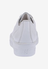 Sneaker bianco in materiale sintetico liscio, forma arrotondata, retro testurizzato e branding discreto sul tallone. Design pulito senza motivi visibili.