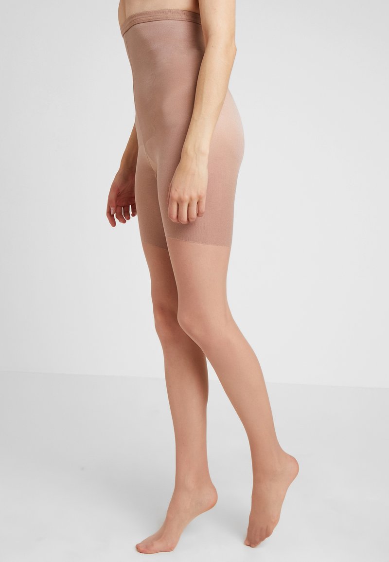 Shorts beiges taille haute en matière élastique. Texture lisse, longueur mi-cuisse, légers et bord supérieur sans couture.
