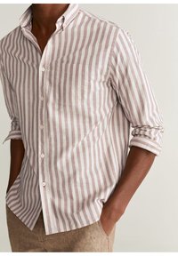 Camisa de manga larga con botones en rayas verticales en rosa claro y blanco, con un bolsillo en el pecho y puños remangados. Tejido de tejido con una textura suave.