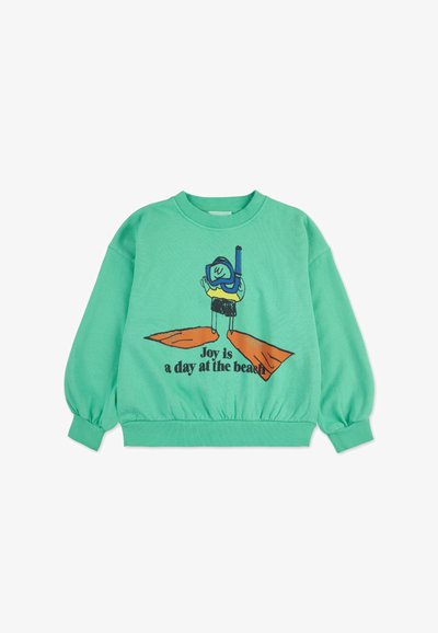 Felpa verde menta con maniche lunghe e orlo a coste. Presenta una grafica di un personaggio che fa snorkeling, con la scritta "La gioia è una giornata in spiaggia."