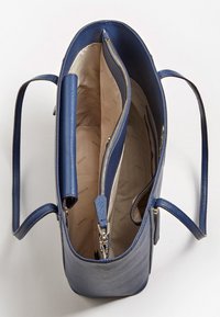 Sac à main bleu marine au design structuré, extérieur texturé, doubles poignées et compartiment zippé. L'intérieur est doté d'une doublure claire.