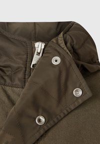 Olivgrön jacka med en quiltad textur, silverdragkedja och tryckknappsdetaljer. Materialet verkar slätt och vattentätt.