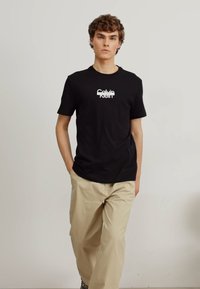 Calvin Klein CUT THROUGH LOGO - Apdrukāts T-krekls - black