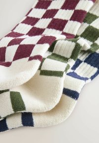 Calze in knit con un motivo a scacchi nei colori borgogna, verde, blu navy e crema; texture morbida con dettagli a coste.
