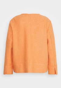 Veste en tissu feutré orange avec une coupe droite, un dos ouvert et des manches larges. Présente des lignes épurées et des accents de couture minimalistes.