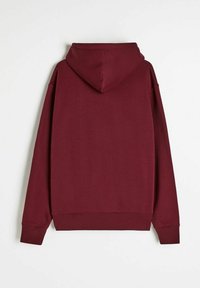 Burgundowa bluza z kapturem, wykonana z miękkiego materiału, z dużym kapturem, luźnym krojem, ściągaczami na mankietach i u dołu. Brak widocznych logo lub wzorów.