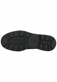 Suela de zapato de goma negra con una superficie texturizada, que presenta un patrón de surcos y perforaciones para tracción y transpirabilidad.