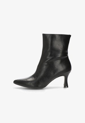 Botín de cuero negro con puntera afilada y tacón curvado de altura media sobre un fondo blanco.