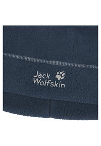 Donkerblauwe fleece stof met een zachte textuur. Bevat witte stiksels en het 'Jack Wolfskin' logo met een pootafdruk accent.