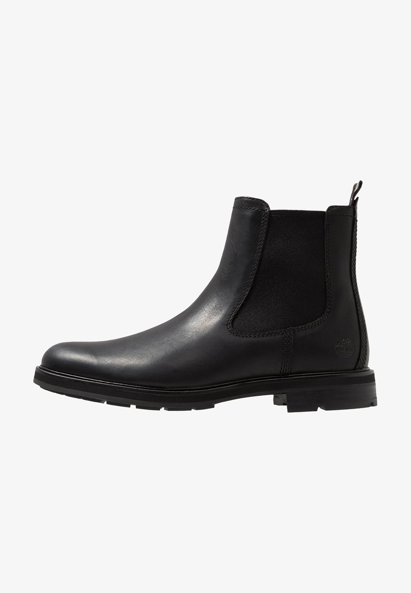 Botte Chelsea en cuir noir avec panneaux latéraux élastiques, languette à l'arrière et semelle en caoutchouc texturée, vue de côté extérieur.