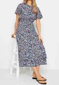 Robe maxi fleurie en bleu marine, avec des fleurs roses claires et bleues. Manches courtes à volant, taille cintrée et jupe à volants avec un design fluide.