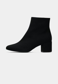 Botas de tornozelo pretas com um design elegante, feitas de um material suave, apresentando uma ponta afiada e um salto quadrado.