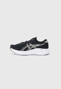 Chaussure de sport noire avec un dessus en maille texturée, des accents argentés, une semelle intermédiaire blanche et une semelle en caoutchouc. Présente un design à lacets.